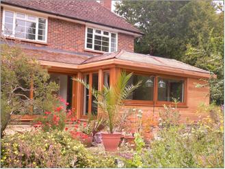 Timber frame extension, cladded in cedar with cedar shingle roof.  Givons Grove, Leatherhead, Surrey